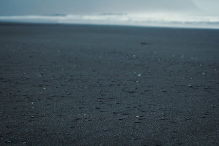 Close up black sand with small rocks concept photo. Iceland landmark. Front view photography with...