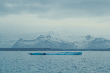 Flat iceberg floating in sea landscape photo. Beautiful nature scenery photography with mountains on...