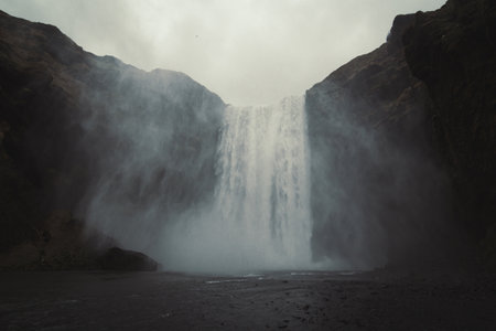 Skogafoss waterfall landscape photo. Iceland nature. Beautiful nature scenery photography with grey sky on background. Idyllic scene. High quality picture for wallpaper, travel blog, magazine, articleの写真素材