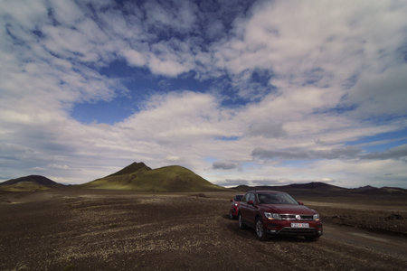 Autos driving across desert valley landscape photo. Beautiful nature scenery photography with...