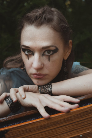 Close up staring woman with druid makeup portrait picture. Witchcore aesthetic. Closeup front view...