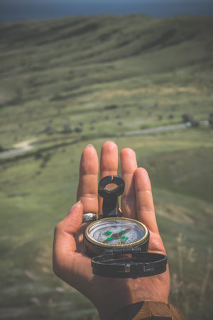Close up woman holding compass concept photo. Navigation at hike. First view person photography with...