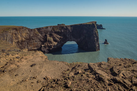 Arch cliff on ocean beach landscape photo. Beautiful nature scenery photography with blue sky on background. Idyllic scene. High quality picture for wallpaper, travel blog, magazine, articleの写真素材