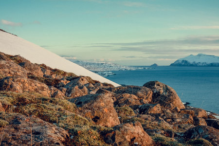 Rocky hill near calm sea landscape photo. Beautiful nature scenery photography with cloudy sky on...