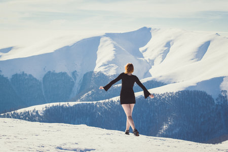 Attractive woman in short dress on mountain scenic photography. Picture of person with snow capped peaks on background. High quality wallpaper. Photo concept for ads, travel blog, magazine, articleの写真素材