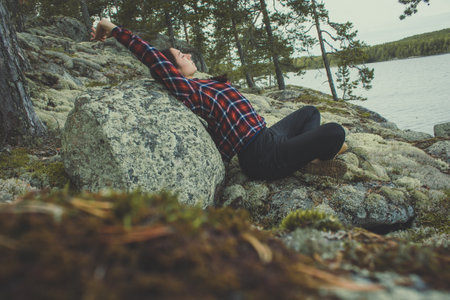 Relax mind with nature scenic photography. Picture of woman stretching, leaning back to rock with landscape on background. High quality wallpaper. Photo concept for ads, travel blog, magazine, articleの写真素材