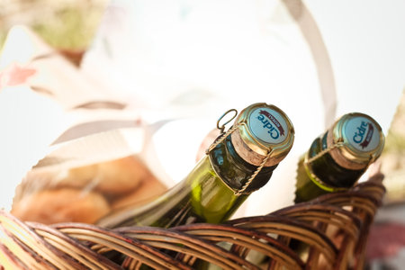 Close up apple cider bottles lying in picnic basket concept photo. Food and alcohol. Front view photography with blurred background. High quality picture for wallpaper, travel blog, magazine, articleの写真素材