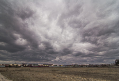 Heavy storm clouds above countryside landscape photo. Beautiful nature scenery photography with...