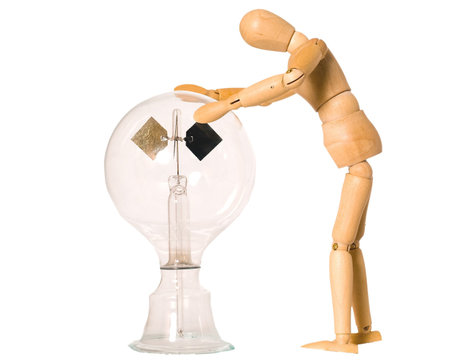 Wooden doll looking at a solar radiometer
