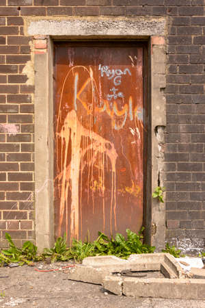 Old rusty metal door with decaying surroundの写真素材