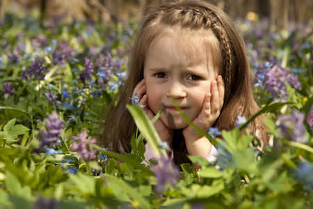 A Girl among colorful flowers in spring forestの写真素材