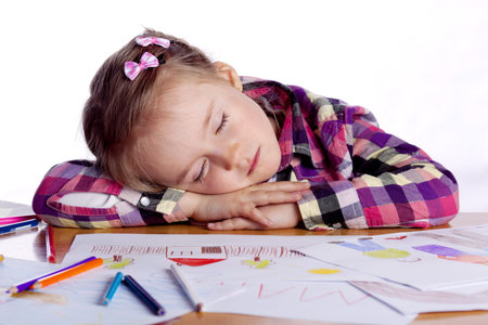 Sleeping child - an artist with sketch and colored pencils in a checkered shirt on a white...