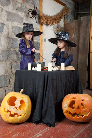 two little witches conjure in an abandoned houseの写真素材