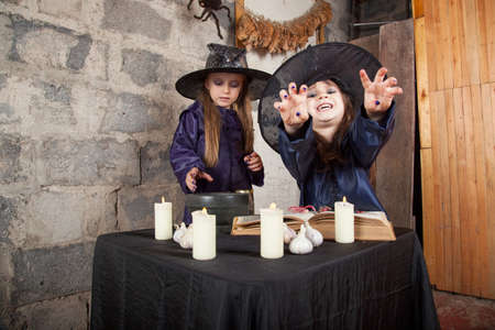 two little witches conjure in an abandoned houseの写真素材