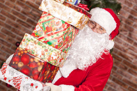 Santa Claus brings Christmas gifts near the Christmas treeの写真素材