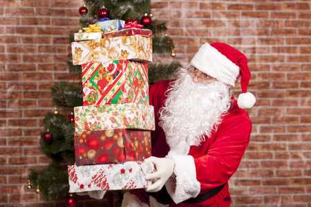 Santa Claus brings Christmas gifts near the Christmas tree