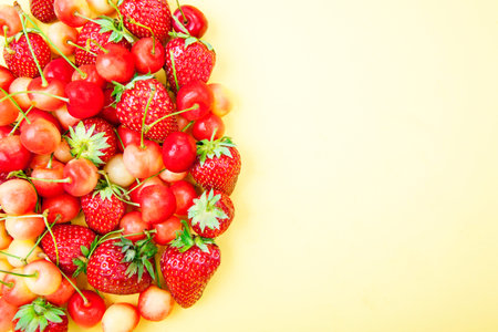Strawberries arranged group on a yellow background