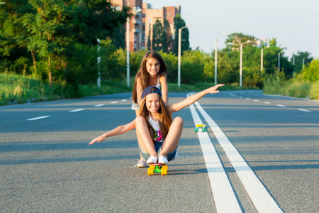 A young girls with penny board outside the city at the road.の写真素材