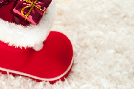 red christmas boot with gifts on white background with copytextの写真素材