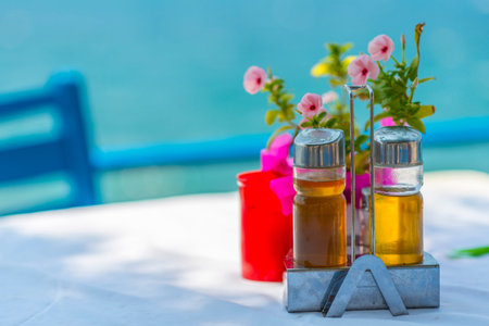 Bottles of Olive Oil And Vinegar On The Table With A Tablecloth Near The Sea in Greece
