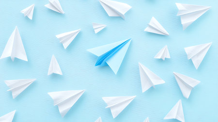 Leadership concept. Paper plane among white paper planes on blue backgroundの素材