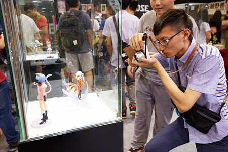 Man taking photograph of figurine at 2015 DL Anime Carnival in Guangzhou, Chinaのeditorial素材