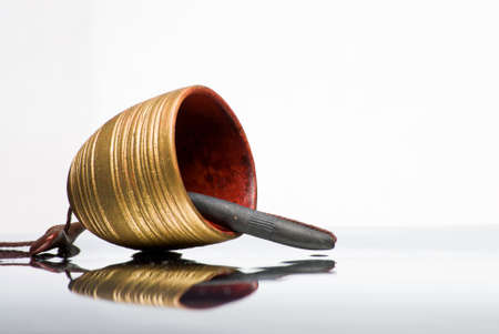 Clay bell hand made lying on reflective surfaceの写真素材