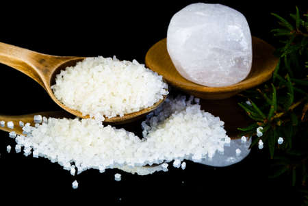 Sea salt on a spoon and mineral salt stoneの写真素材