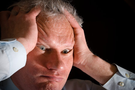 Portrait of a man holding his head