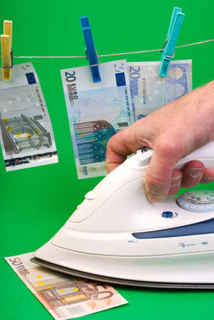 Iron over the banknote and euro drying in the backgroundの写真素材