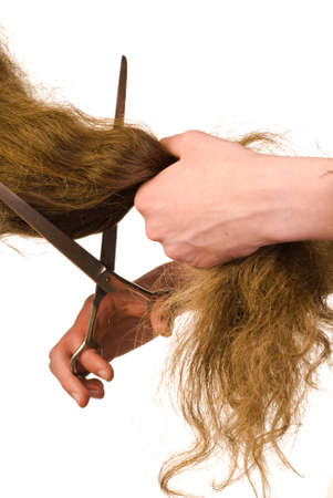 Scissors cutting long beautiful hairs on white backgroundの写真素材