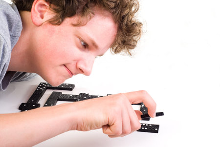 The boy bent down and put the domino