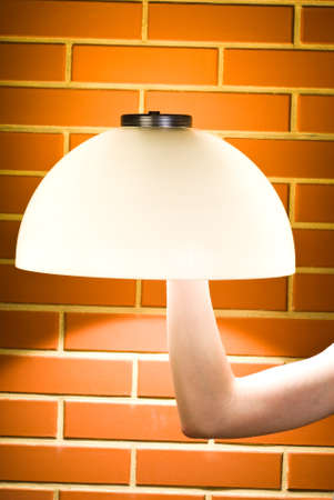 Lampshade mounted on the arm against brick wallの写真素材