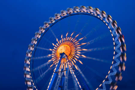 Illuminated Ferris wheel at the oktoberfest in munich at nightの写真素材
