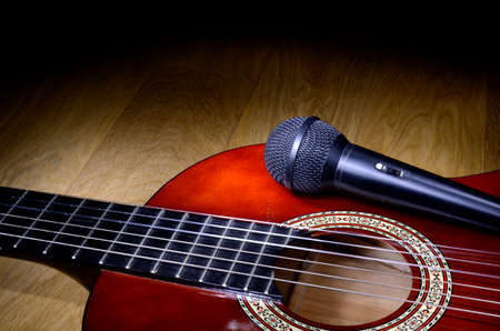 Closeup of microphone placed on acoustic guitar bodyの写真素材