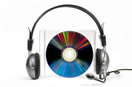 Headphones on compact disk in box against white background