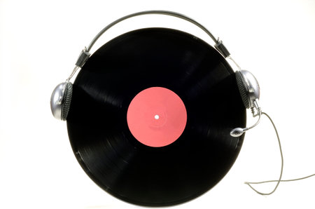Headphones with microphone worn by vinyl record album on white background