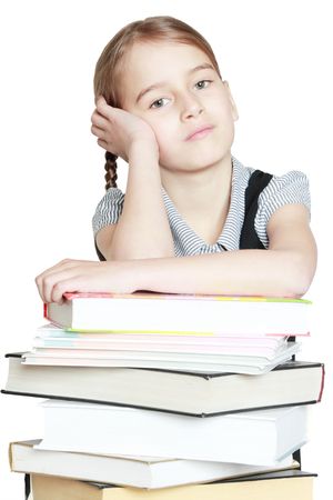 Young girl leaned over pile of books isolated on whiteの写真素材