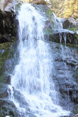 Mountain river flowing on  rock covered with  mossの写真素材