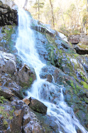 Mountain river flowing on  rock covered with  mossの写真素材
