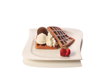 Waffles with Chocolate, vanilla ice cream, whipped cream and strawberries. Isolated on white background.の写真素材