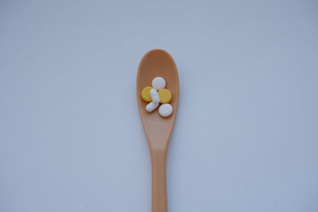 Tablets in a spoon on a white background. Top view.の写真素材