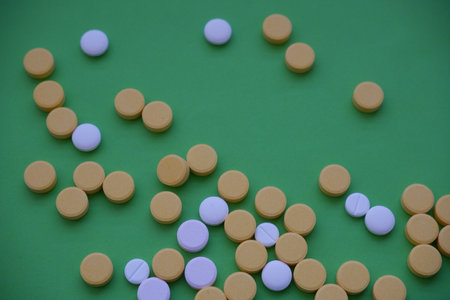 Medicine pills on green background. Top view. Copy space.