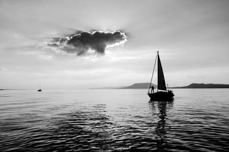 The little boat is sailing on the water with Captain on boardの写真素材