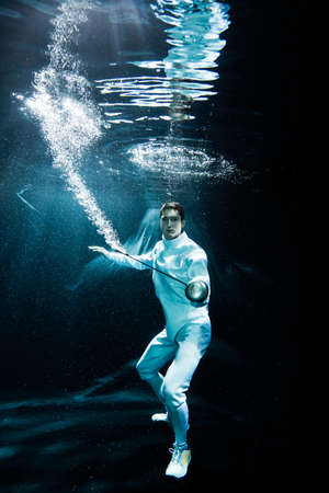a male fencer fighting underwater with an EPEE