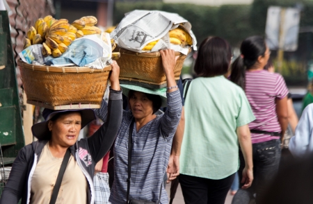 Baguio City, Philippines- May 23, 2013: Ripe bananay peddler carrying there goods during early morning within the vicinity of city proper.のeditorial素材