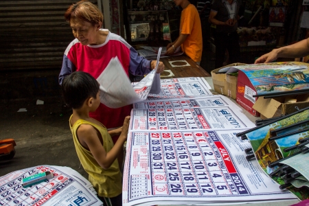 An old woman arranging 2014 calendars in the street of Recto, Manila,Philippines, Sunday December 22,2013 のeditorial素材