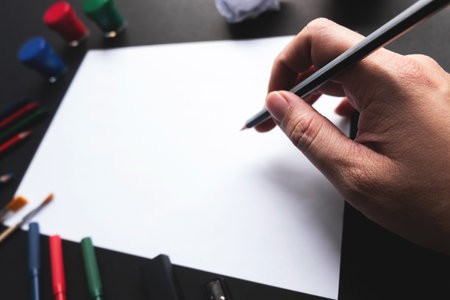 Man hand start using pencil drawing on empty white sheet of paper with art tools.の写真素材