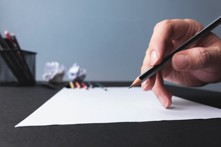 Man hand start drawing with pencil on empty white sheet of paperの写真素材
