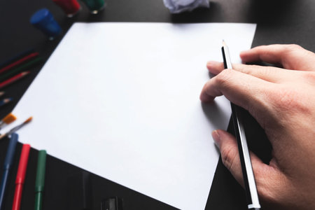 Man hand start using pencil drawing on empty white sheet of paper with art tools.の写真素材